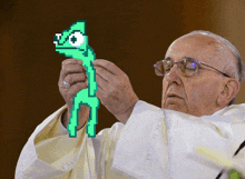 a man in glasses holds a green pixelated lizard with the number 50 on its head