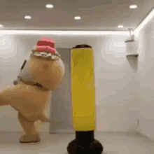 a stuffed animal in a mascot costume is kicking a punching bag in a room .