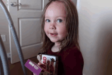 a little girl is holding a box that says mom aid