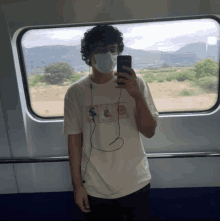 a man wearing a mask takes a selfie with his phone