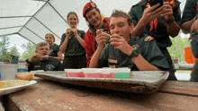 a group of boy scouts are playing with a tray of jelly