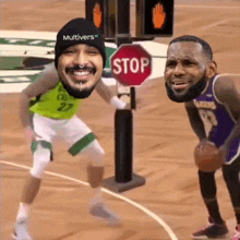 two basketball players are standing next to a stop sign on the court