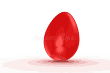 a red easter egg is sitting on a white surface