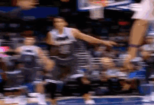 a blurry picture of a basketball game with a player jumping in the air .