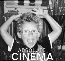 a black and white photo of a boy with glasses and the words absolute cinema on the bottom