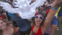 a crowd of people at a festival with one wearing a mask that says " cool dance with us "