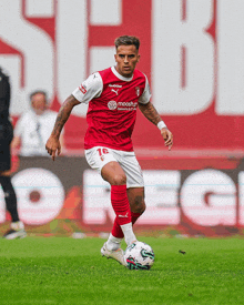 a soccer player wearing a red and white uniform with the number 16 on it