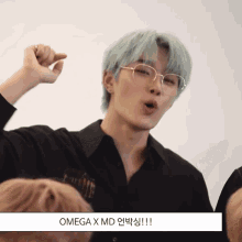 a man wearing glasses and a black shirt with omega x md written below him