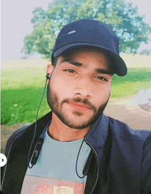 a man with a beard wearing a hat and earbuds