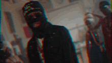 a man wearing a ski mask and sunglasses stands in a blurry photo