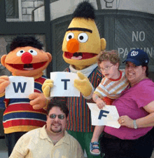 sesame street characters are posing for a picture with people