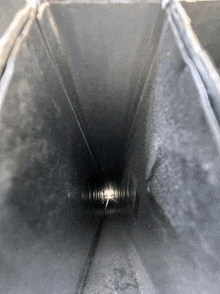 the inside of a metal duct with a light shining through it