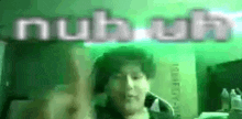 a man is making a funny face in front of a green background with the word nub written on it .