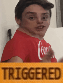 a young boy wearing a red coca cola shirt