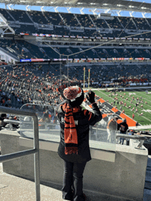 a person wearing a browns jersey and scarf