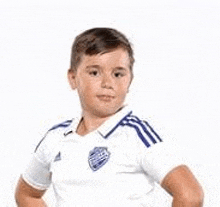 a young boy is wearing a white and blue soccer uniform .