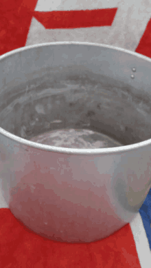 an aluminum bowl is sitting on a red white and blue blanket