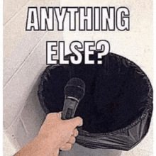 a person holding a microphone in front of a trash can that says anything else ?