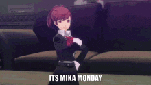 a girl in a suit stands in front of a couch with the words " its mika monday " written below her