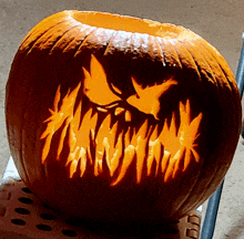 a pumpkin with a scary face carved into it is sitting on a chair