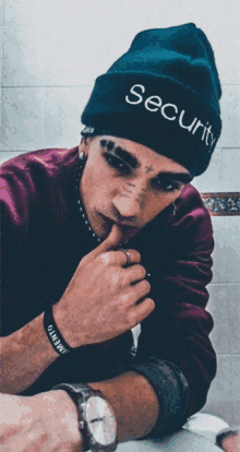 a man wearing a blue beanie that says security on it