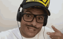 a man wearing headphones and a hat that says " ice the wall " on it