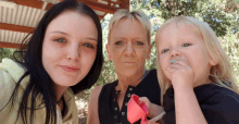 two women and a little girl are posing for a photo