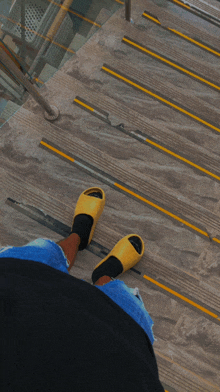 a person wearing yellow sandals is standing on stairs