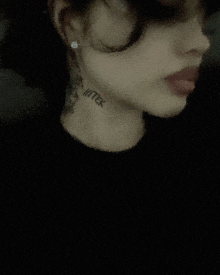 a close up of a woman 's face with a tattoo on her neck that says hitek