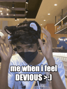 a man wearing a mask and a cat ear headband says " me when i feel devious "