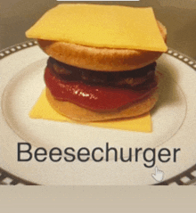 a hamburger with ketchup and cheese on a plate that says beesechurger on it