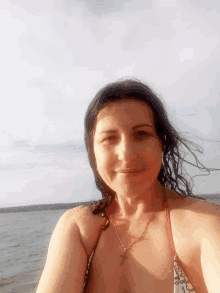 a woman in a red bikini is taking a selfie on a beach