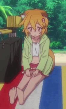 a girl with a cat ear is sitting on a beach towel with her legs crossed .