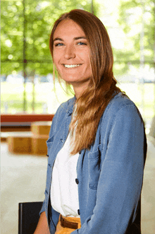 a woman in a blue shirt and white shirt smiles