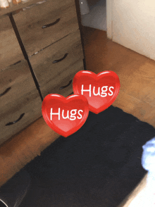 two red hearts that say hugs are floating in the air