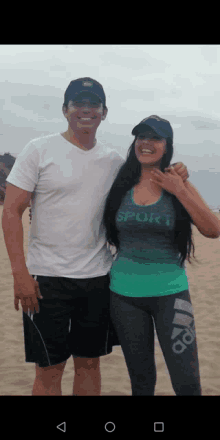 a man and a woman are posing for a picture on the beach