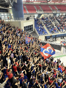 a crowd of people in a stadium holding up a flag that has the number 3 on it