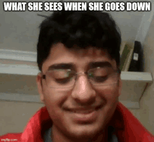 a young man wearing glasses and a red jacket is smiling with a caption that says what she sees when she goes down