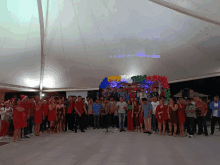 a group of people are posing for a picture in front of a christmas party banner