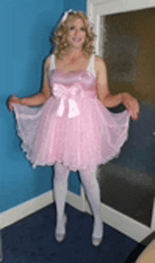 a woman in a pink dress and white tights is standing in a room