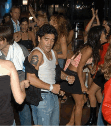 a man with a che guevara tattoo on his arm dancing in a crowd