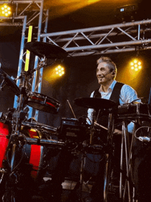 a man is playing a drum set with a microphone on