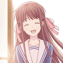 a girl with long brown hair and a pink bow in her hair is smiling and wearing a school uniform .