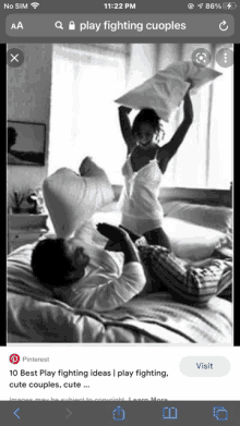 a man and a woman are having a pillow fight in bed