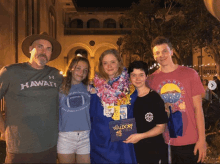 a man in a hawaii shirt poses with his family