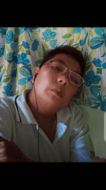 a young man wearing glasses and earbuds takes a selfie