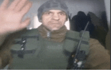 a man in a military uniform is waving his hand in a blurry photo