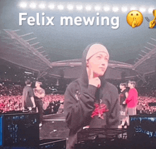 a man in a hoodie stands in front of a crowd with the words felix mewing written above him