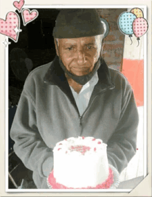 a man in a gray jacket is holding a cake