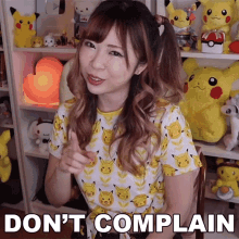 a girl in a pikachu shirt says " do n't complain " in front of stuffed pikachus